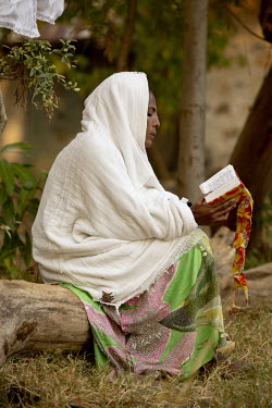 A young woman reads from a religious text at Debre Dina church.