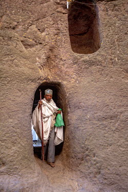 An elderly religious man uses the narrow passage ways at Medhane Alem church.