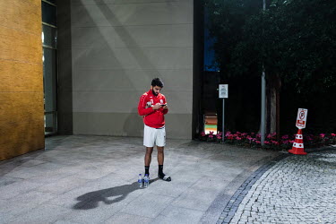 Norlla Amiri of the Afghan national football team, checks his smartphone after a training session.