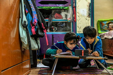 Ishita (L) and Rudra (R) attend an online class at their home. Due to COVID-19 restrictions schools are closed.