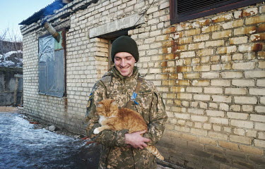 Kombat (nickname) with a cat. He is part of a Ukrainian brigade located in makeshift accommodation near the Russian border. The brigade takes care of four cats and one dog.