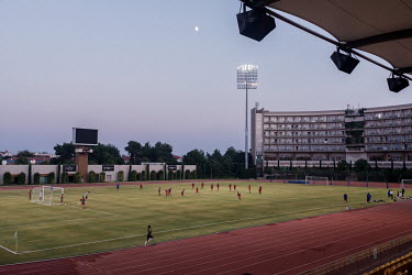 Floodlights illuminate the pitch for the Afghan national football team's night training session.