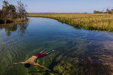 Farmer Ruivaldo Nery swims in a pool of clear water around the headquarters of his farm in the Pantanal of Paiaguas that is permanently flooded. This flooding occurred due to the 'breaking in' of the...