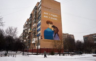 Mural on the side of a tower block shows an embracing couple and reads 'Peace for our country. Peace for Ukraine.'