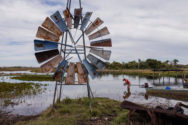 Farmer Ruivaldo Nery repairs the motor of his canoe (rabeta), the only means of transport used to travel through this permanently flooded area in the Pantanal of Paiaguas, where his farm is located. T...