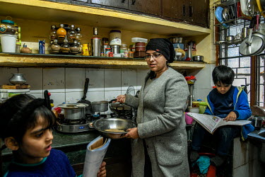 Anuradha, a single mother and a lawyer, multi-tasking as she cooks in her kitchen while helping with her children's, Ishita and Rudra, studies. Due to COVID-19 restrictions schools and offices are clo...