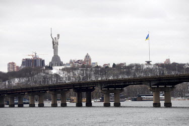 The Batkyvshina Mat (Motherland) Monument in Kyiv with a bridge over the Dnieper river in the foreground.