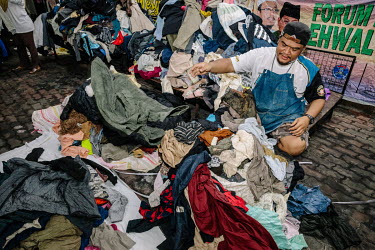 Muhammad Mat Nor the owner of Mad X Station bundle shop sorting out clothes he unpacks from bales. He says business has been much slower since the pandemic. People in Malaysia use the term 'bundle' fo...