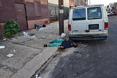 Two men, surrounded by drug injecting paraphernalia, passed out on a street in North Philadelphia, between Huntingdon and Allegheny on the elevated Market-Frankford subway. This is the epicentre of th...