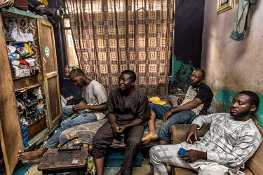 Ayandele Olushola (39), a commercial motorbike rider, in the 3x3 metre room where he and five other men live in Mushin a working-class district of Lagos.