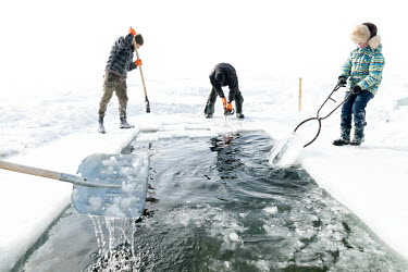 Members of the 'Walrus' swimming club cut ice from the frozen surface of Lake Baikal to make an entrance point for bathers.