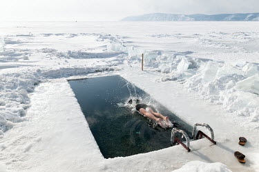 A member of the 'Walrus' swimming club plunges into a pool cut through the frozen surface of Lake Baikal.