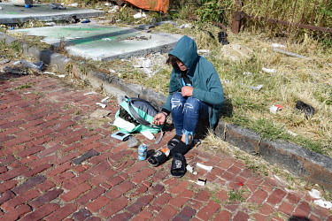 A woman prepares to inject herself on the street in North Philadelphia, between Huntingdon and Allegheny on the elevated Market-Frankford subway. This is the epicentre of the city's opioid (fentanyl)...