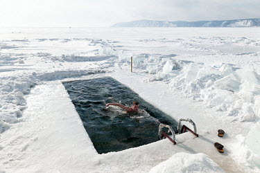 A member of the 'Walrus' swimming club swims in a pool cut through the frozen surface of Lake Baikal.