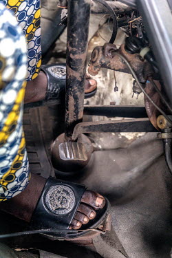 A driver using th efoot pedals in his commercial transportation bus, popularly known as 'Danfo', as it makes its way along the Lekki-Epe expressway, which is notorious for its traffic jams.