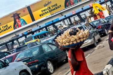 A street vendor selling snacks to drivers caught in wueues on the Lekki-Epe expressway, which is notorious for its traffic jams.