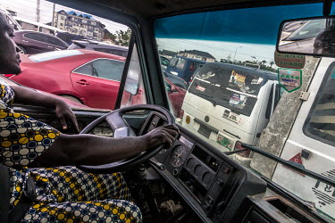 A driver steering his commercial transportation bus, popularly known as 'Danfo', along the Lekki-Epe expressway, which is notorious for its traffic jams.