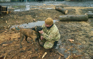 Zurab, a military intelligence officer, plays with a village dog called Dik five miles from the frontlines.