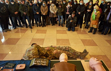 Civilians look at a first aid demonstration as the Azov Battalion conducted military training for citizen volunteers. About hundred people learned first aid and how to use rifle. It was the first time...