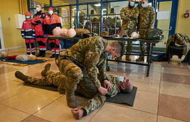 A soldier shows how to stop a bleeding artery during a first aid demonstration as the Azov Battalion conducted military training for citizen volunteers. About hundred people learned first aid and how...