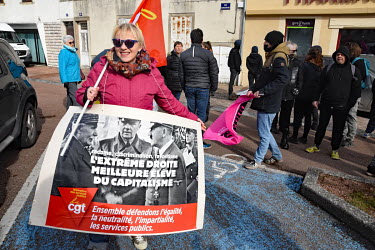 A woman holds a placard showing Philippe Petain shaking hands with Adolf Hitler at a counter demonstration during a rally for far right presidential candidate Eric Zemmour.