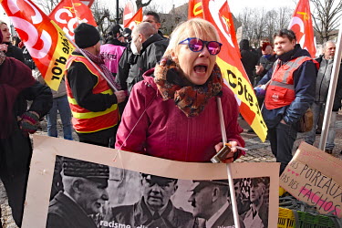 A woman shouts while holding a placard of Philippe Petain and Adolf Hitler at a counter demonstration during a rally for far right presidential candidate Eric Zemmour.