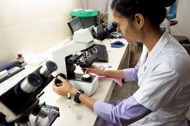 A technician examines a sample under the microscope at a laboratory in Duncan hospital.