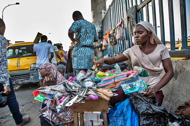 Saidat Bunmi Ayanwole, a street vendor in the Idumota market, selling cutlery from her roadside stall.