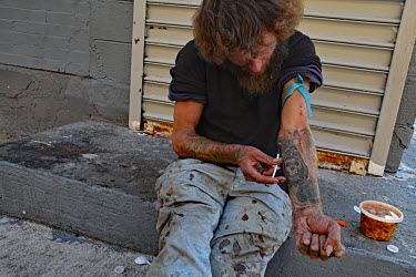 A drug users injecting himself on the street in North Philadelphia, between Huntingdon and Allegheny on the elevated Market-Frankford subway. This is the epicentre of the city's opioid (fentanyl) drug...