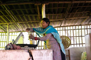 Extracting vermicelli for fried snacks over a smokeless stove.