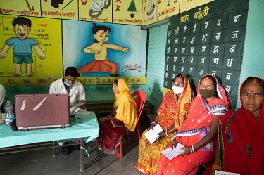 Medical staff at an outreach eye clinic in a primary school, test for cataracts.