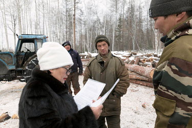 Elena Bayandaevna, an indigenous Buryat activist, checks the paperwork presented by a logging company near her native village Zurtsagan. The area is a part of Lake Baikal protected ecological zone. Th...