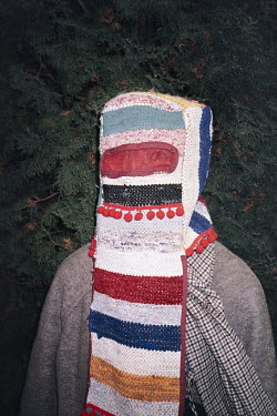 A person dressed-up in character for a rural winter carnival.