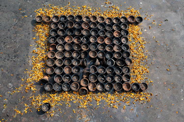 Burnt out butter (oil) lamps and marigold petals after a ceremony at a Buddhist pilgrimage site.