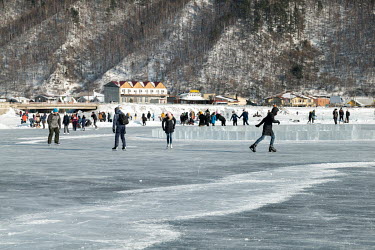 Tourists skating on an ice rink made on the frozen surface of Lake Baikal in Listvyanka, one of the many tourist centres built illegally beside Lake Baikal. Most such developments do not have sewage t...
