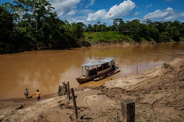 Children play beside a boat moored in the Dois Irmaos community on the banks of the Acre River in the Chico Mendes Extractive Reserve.
