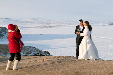 Newlyweds pose for a photo shoot at Cape Burkhan despite the temperature of -27 C