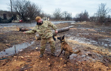 Zurab, a military intelligence officer, plays with a village dog called Dik five miles from the frontlines.