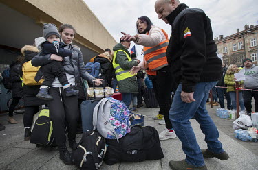 Ukrainian refugees, fleeing the Russian invasion, are met off a train by Polish volunteers and relief agency staff in the border town of Przemysl where they are offering food and help with accomodatio...