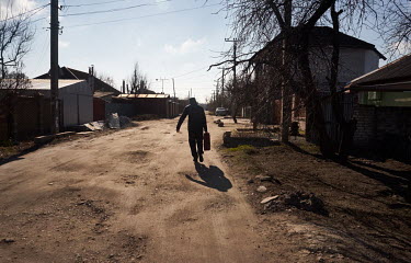 A man carries a canister full of fuel from a nearby petrol station. He says he is thinking of leaving Zaporizhia, but has not decided when yet.