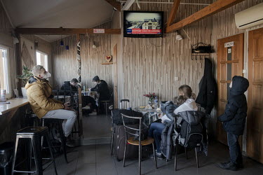 Refugees fleeing the Russian invasion of Ukraine watch news reports of the conflict while waiting in a cafe soon after crossing the border at Medyka â�" Shehyni.