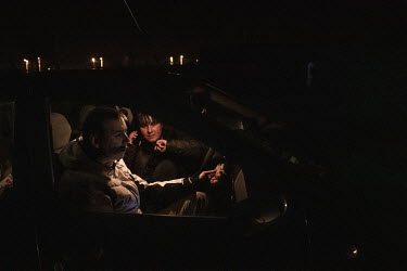 A couple wait in a car at the Medyka border crossing where they have come to help Ukrainians fleeing the Russian invasion. Many people have travelled to Polish/Ukrainian border crossings with food, he...