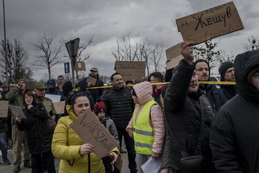 Volunteers hold signs indicating offers of free onward travel as they meet Ukrainian refugees, fleeing the Russian invasion, off buses in Przemysl, near the border with Ukraine.