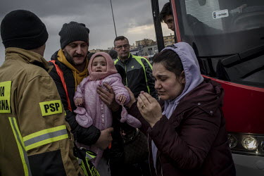 Volunteers from the fire department meet Ukrainian refugee families, fleeing the Russian invasion, off buses in Przemysl, near the border with Ukraine.