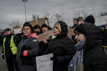 Volunteers hold signs indicating offers of free onward travel as they meet Ukrainian refugees, fleeing the Russian invasion, off buses in Przemysl, near the border with Ukraine.