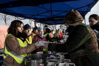 Food prepared by volunteers is being distributed in a commercial centre car park which has become the main transit centre for refugees fleeing the Russian invasion of Ukraine.