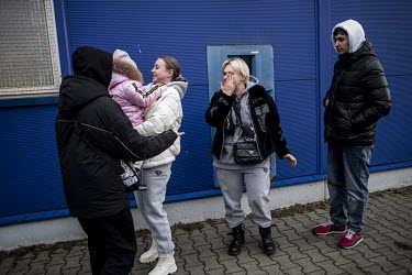 A Ukrainian family is reunited in a commercial centre car park which has become the main transit centre for refugees fleeing the Russian invasion of Ukraine.