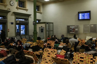 Refugees fleeing the Russian invasion of Ukraine rest on camp beds in a reception centre at the main railway station in Przemysl.