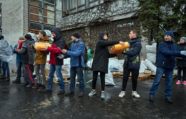Volunteers unloading plastic dishes at a distribution centre. Residents of Dnipro have been bringing clothes, mats, canned food, cigarettes, bottled water and more. Volunteers then sort all donated it...