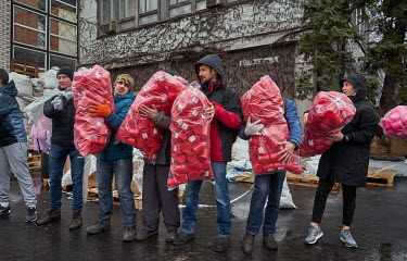 Volunteers unloading bags full of plastic mugs at a distribution centre. Residents of Dnipro have been bringing clothes, mats, canned food, cigarettes, bottled water and more. Volunteers then sort all...